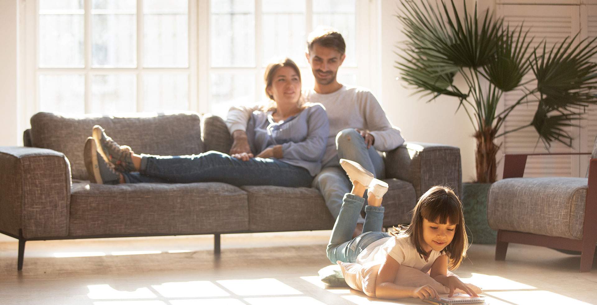 família sentada ao sofá em dia de sol